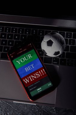 Kumar mobil uygulamalı akıllı telefon ve klavyede futbol topu. Dikey resim