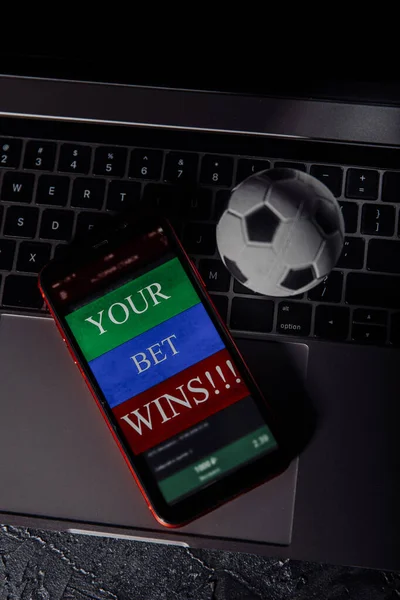 Smartphone com aplicação móvel de jogo e bola de futebol em um teclado. Imagem vertical — Fotografia de Stock