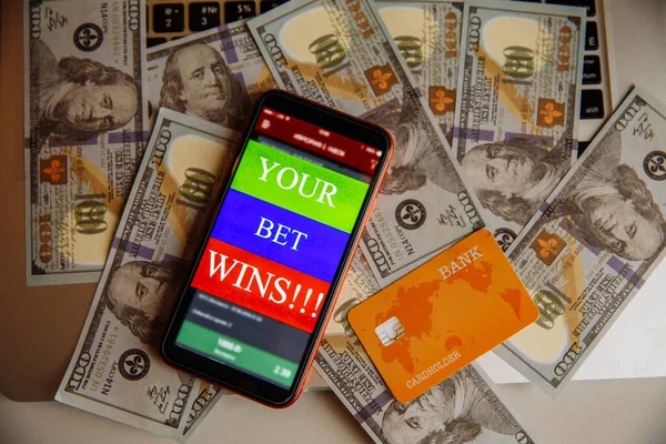 Smartphone con aplicación móvil de juego y tarjeta de crédito en billetes de dólar — Foto de Stock