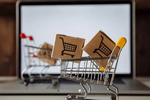 Trollies con cajas de papel para entrega a los clientes. Transacciones comerciales realizadas electrónicamente en Internet para la venta a distancia — Foto de Stock