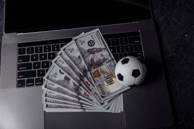 Klavyede futbol topu ve dolar banknotları. Spor, kumar, para kazanma konsepti