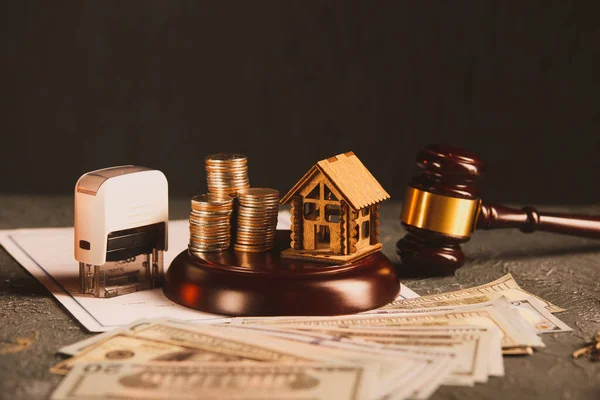 Real Estate Law concept. Wooden model of house, money and judge gavel on contract