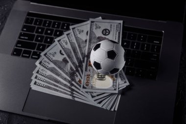 Bahisler, spor bahisleri, bahisçi konsepti. Dizüstü bilgisayarda futbol topu.