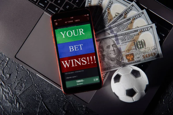 Smartphone com aplicação móvel de jogo, bola e notas de dinheiro em um close-up teclado. Esporte e conceito de apostas — Fotografia de Stock