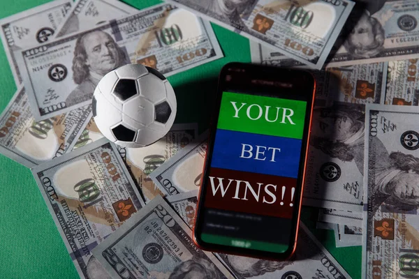 ギャンブルモバイルアプリケーションとお金のクローズアップとサッカーボールとスマートフォン。スポーツと賭けの概念 — ストック写真