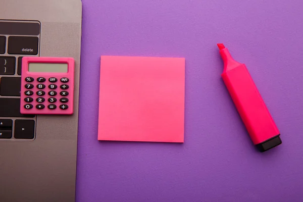 Posto di lavoro casa creativa con calcolatrice, laptop e nota adesiva rosa, posto per il testo. Lavoro dal concetto di casa — Foto Stock