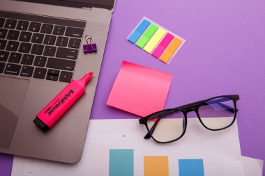 Dizüstü bilgisayarlı, gözlüklü ve pembe yapışkan notlu yaratıcı iş yeri