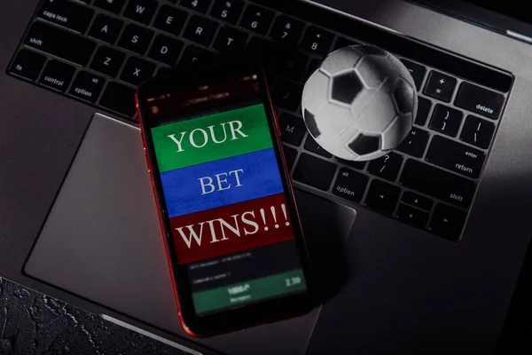 Smartphone com aplicação móvel de jogo e bola de futebol em um teclado. Esporte e conceito de apostas — Fotografia de Stock