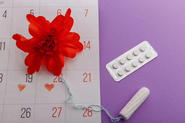 Menstruationszyklus und Hygienekonzept bei Frauen. Menstruationskalender mit Tampon, Pillen und roter Blume — Stockfoto