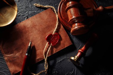 Adalet terazisi, zarf ve ahşap hakimler yakın plan çekimde. Hukuk ve adalet kavramı