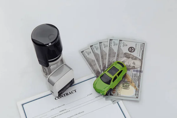 Purchase contract for a car with dollar banknotes, stamps and car keys on a white background