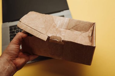 Bir elde bozuk karton kutu. Online alışveriş ve teslimat konsepti. Sevkiyat kazası.