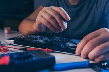 Bilgisayar tamir atölyesi. Mühendis dizüstü bilgisayar bakımını yapıyor. Elektronik bileşenleri tamir eden donanım geliştiricisi.