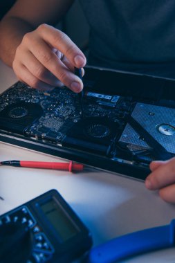 Bilgisayar tamir atölyesi. Mühendis dizüstü bilgisayar bakımını yapıyor. Elektronik bileşenleri tamir eden donanım geliştiricisi.