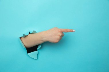 Kadın kollarını kırıyor. Mavi duvar, açık alanda olduğunu gösteriyor. Tavsiye veriyor.