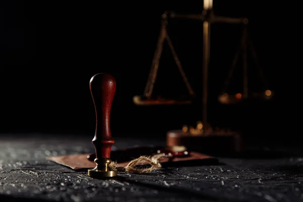 Prawo i sprawiedliwość. Narzędzia notarialne. Wagi sprawiedliwości, brązowa koperta z pieczęcią i drewnianym znaczkiem na sali sądowej — Zdjęcie stockowe