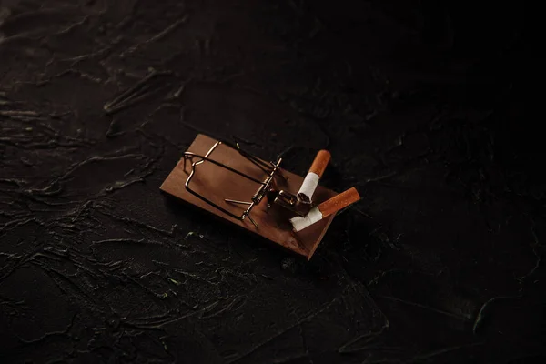 Des cigarettes dans un piège à souris. Concept dangereux habbit — Photo