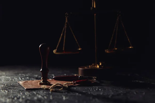 法と正義の概念。正義のスケール、灰色のテーブルの上にシールと木のスタンプが付いている封筒 — ストック写真