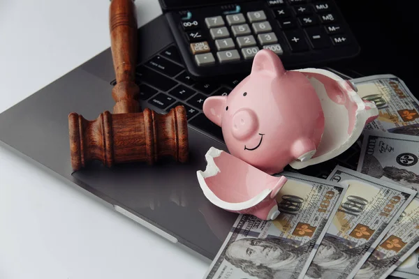Broken piggy bank, dollar bills and gavel on keyboard. Auction and bankruptcy concept