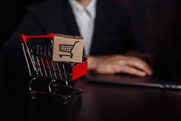 Concept d'achat en ligne. Ordinateur portable avec mini chariot de marché et deux boîtes en papier — Photo