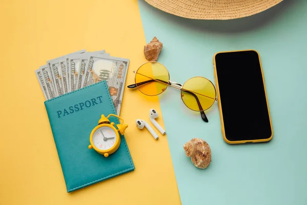Έννοια του τουρισμού. Ταξιδιωτικά αξεσουάρ και διαβατήριο με χρήματα σε μπλε κίτρινο φόντο — Φωτογραφία Αρχείου