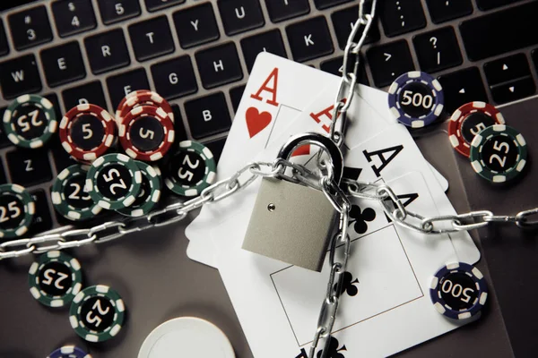 Law and rules for online gambling concept, padlock and playng cards on laptop keyboard