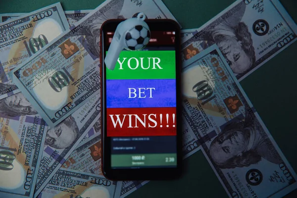 ドル紙幣と緑の背景に賭けアプリケーションとホイッスルとスマートフォン。ギャンブルと賭けの概念。トップ表示 — ストック写真
