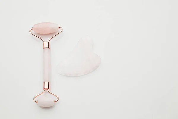 Masážní nástroj Pink Gua Sha. Péče o pleť obličeje doma, anti-aging a zvedání terapie — Stock fotografie