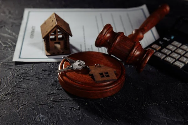 Деревянный дом, ключи и судьи молоток на столе. Ипотека, банкротство или развод — стоковое фото