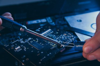Bilgisayar tamir atölyesi. Mühendis dizüstü bilgisayar bakımını yapıyor. Elektronik bileşenleri tamir eden donanım geliştiricisi.