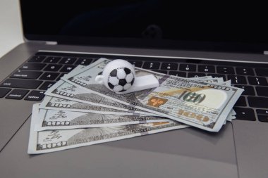 Futbol düdüğü ve klavyede dolar banknotları. Çevrimiçi spor konseptine bahis