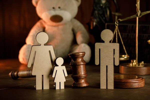 Wooden figures of family with teddy bear and gavel on a table close-up. Divorce and alimony concept — Stock Photo, Image