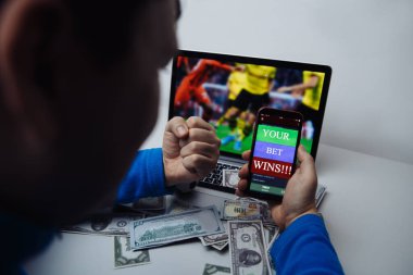 Man watching football match online broadcast on his laptop and celebrate after winning jackpot in online bet