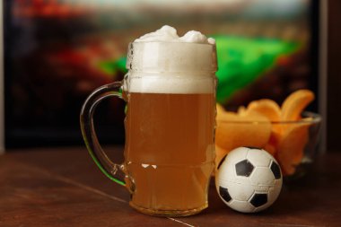 Bardakta bira, ekranın önünde de futbol maçı. Futbol taraftarları