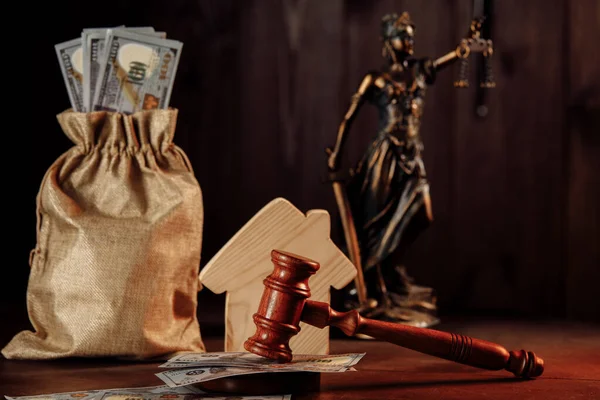 Τσάντα με λεφτά, σπίτι και σφυρί με την κυρία της δικαιοσύνης. Έννοια δημοπρασίας ακινήτων — Φωτογραφία Αρχείου