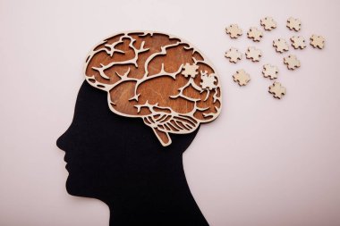 Beyni ve ahşap yapbozu olan bir adam. Alzheimer hastalığı, bunama ve akıl sağlığı konsepti
