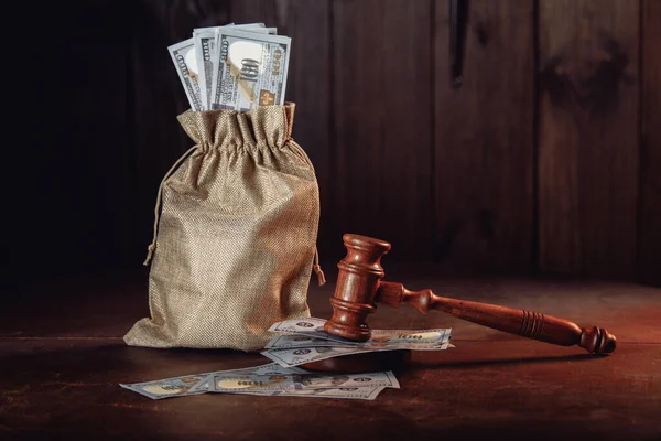 Money bag with dollar banknotes and judges gavel. Litigation, dispute resolution, conflict of interest settlement