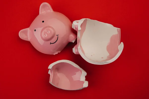 Banco piggy quebrado no fundo vermelho — Fotografia de Stock