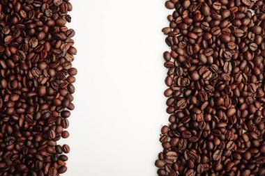 Kahverengi kahve çekirdekleri beyaz arka planda izole edilmiş.