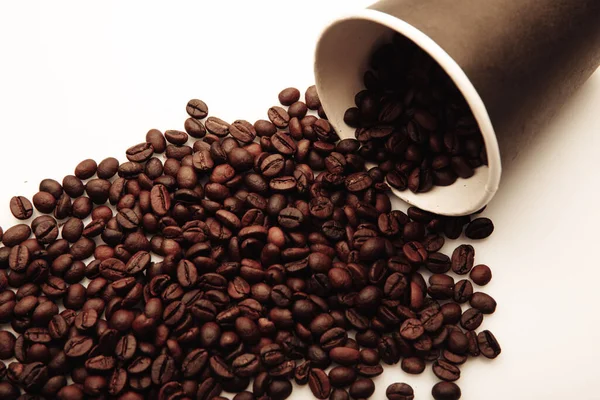 Taza de café llena de granos de café primer plano sobre fondo blanco — Foto de Stock