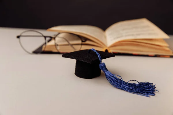 Gorra de graduación y vasos con libro abierto. Concepto de educación y ciencia — Foto de Stock