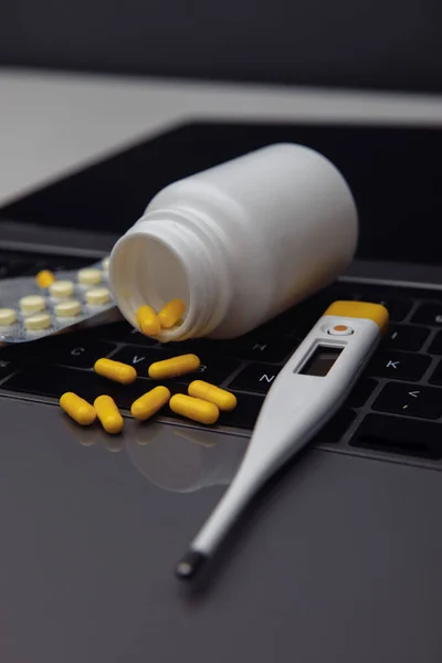 Online shopping. Pills, thermometer and container on the laptop. Vertical image — Zdjęcie stockowe