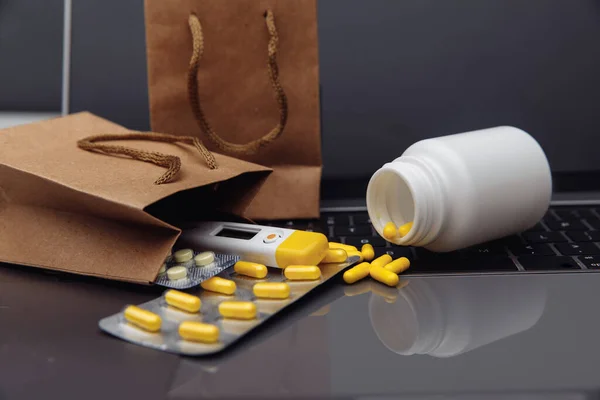 Torby z tabletkami i narkotykami na klawiaturze laptopa. Zakup leków online motyw — Zdjęcie stockowe