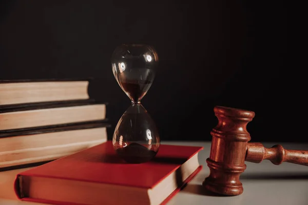 Concepto de ley. Reloj de arena en el libro y el martillo juez —  Fotos de Stock