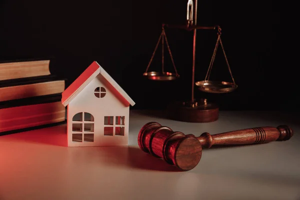 Soudce aukce a realitní koncept. Model domu a kladívko na stole — Stock fotografie