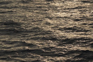 Deniz yüzeyi. Kurşun grisi su, küçük dalgalar ve ay ışığı yolu. Arkaplan resmi.