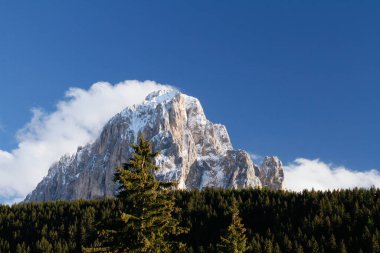 Langkofel, Sassolungo Karı Dağ Tepesi 'nin tepesinde asılı bulutlarla kaplı. Sasso Lungo 'nun altındaki Kalın Orman, Lang Kofel. Selva di Val Gardena 'dan.