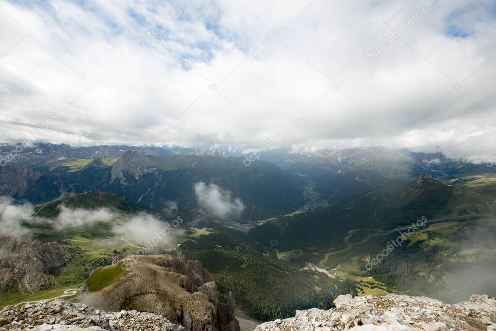 View from top of Sass Pordoi down in the Valleys of Fassa. Wide Landscape of the Dolomites in Italy