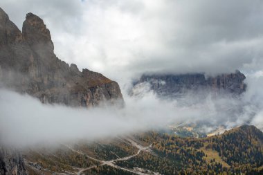 Sassolungo Bulutlarla kaplı, ve Sella Dağı solda Dolomitlerle kaplı Güney Tyrol 'da Val Gardena' nın üzerinde