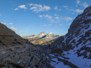 Passo Falzarego 'nun yukarısındaki Dolomitlerdeki Monte Averau Havalimanı. MonteAverau in the Sun, Shadow 'daki karanlık bir vadiden bakıyor